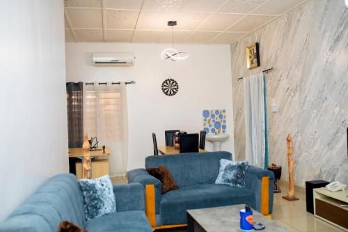a living room with two blue couches and a table at Appartement HAVRE DE PAIX in Abomey-Calavi