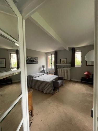 a bedroom with a bed and a couch in a room at Chambre Joséphine in Saint-Cloud