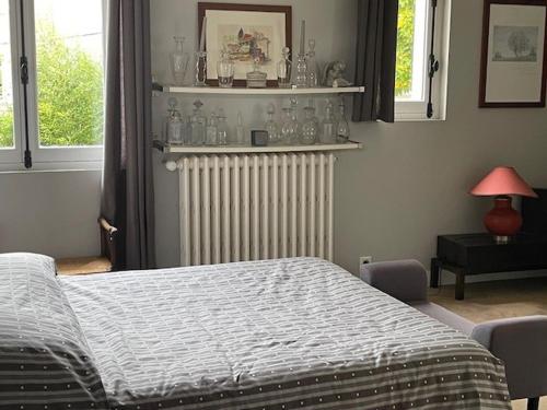 a bedroom with a bed and a radiator and windows at Chambre Joséphine in Saint-Cloud