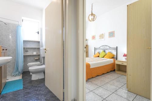 a bedroom with a bed and a toilet and a sink at Villa Cristina a marina di Capilungo - Apulia Home in Capilungo