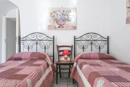 a bedroom with two beds and a table with a lamp at Villa Cristina a marina di Capilungo - Apulia Home in Capilungo