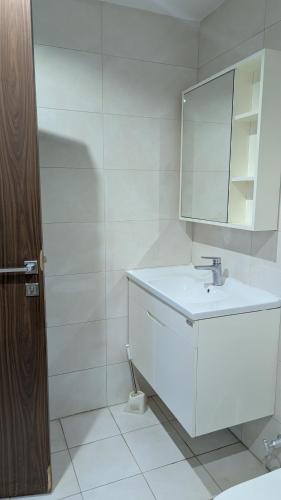 a white bathroom with a sink and a mirror at Dragon Premium Homes in Dubai