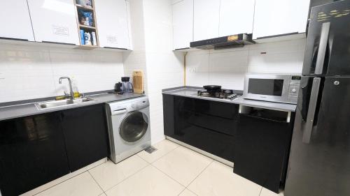 a kitchen with a washing machine and a microwave at Dragon Premium Homes in Dubai