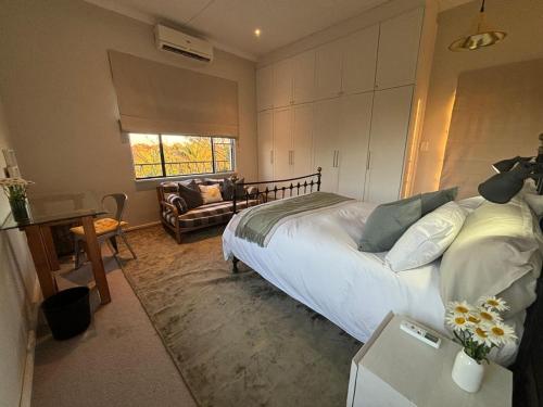 a bedroom with a large bed and a living room at Otjiwarongo Farmstay in Otjiwarongo