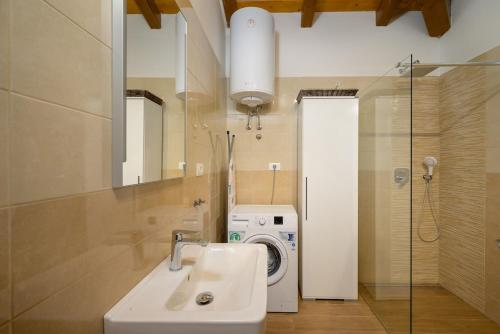 a bathroom with a sink and a washing machine at Villa RE by Istrialux in Svetvinčenat