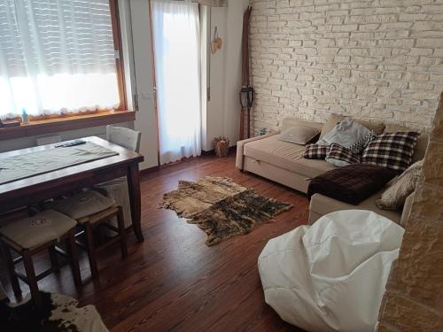 a living room with a couch and a table at L'appartamento pianoterra in Gallio