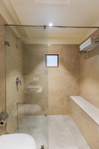a bathroom with a shower and a tub and a sink at SaffronStays Sylvan Farms in Delmāra