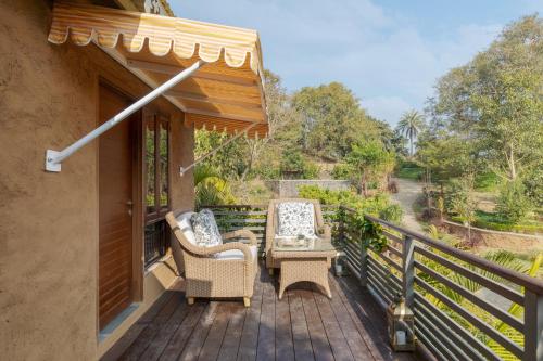 a balcony with a table and chairs on a deck at SaffronStays Sylvan Farms in Delmāra