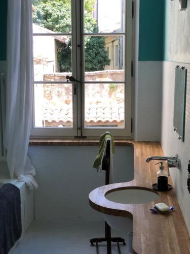 une salle de bain avec un lavabo et une fenêtre dans l'établissement Studio de caractère intra-muros, à Avignon