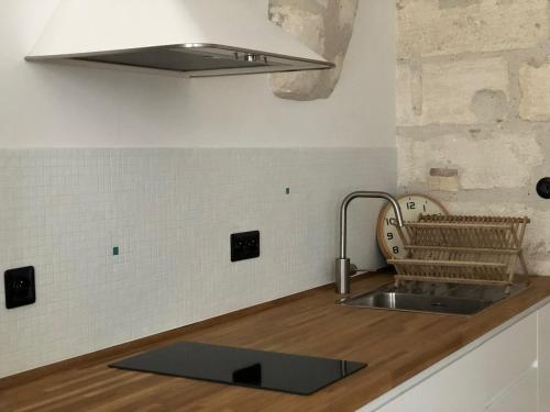 une cuisine avec un évier et un plan de travail dans l'établissement Studio de caractère intra-muros, à Avignon
