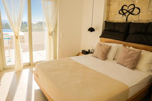 a bedroom with a large bed with a large window at Nikiti Dream Villas in Nikiti