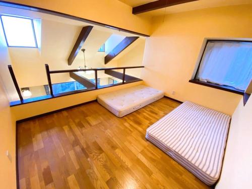 una habitación con dos camas y dos ventanas en 絶景温泉付き別荘, en Higashiizu