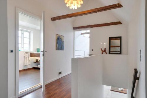 a room with white walls and a hallway with a mirror at Entire holiday home in Slagelse
