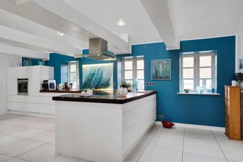 a large kitchen with blue walls and a counter at Entire holiday home in Slagelse