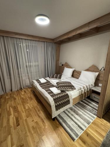 a bedroom with a large bed with a rug at Apartman A55 Aparthotel Vučko privatni apartman in Jahorina