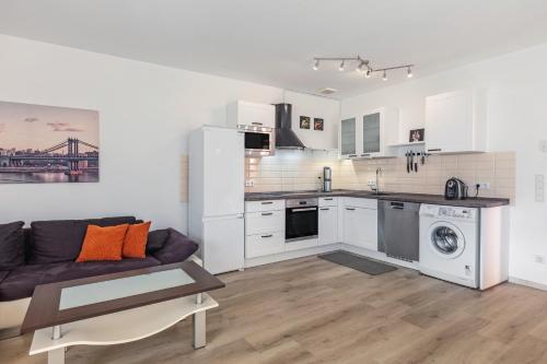 a kitchen and living room with white cabinets and a couch at Schöne 2 Zimmer Wohnung Flieden in Flieden