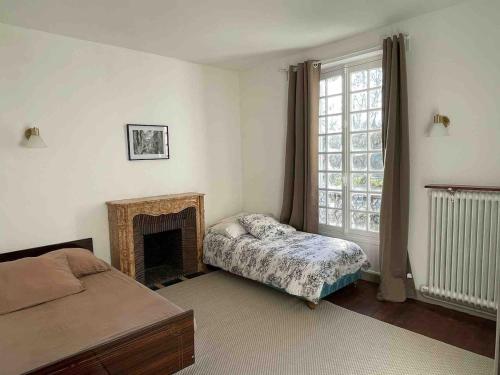 une chambre avec un lit et une cheminée dans l'établissement Grand Maison avec Piscine et Sauna, à La Ferté-Gaucher