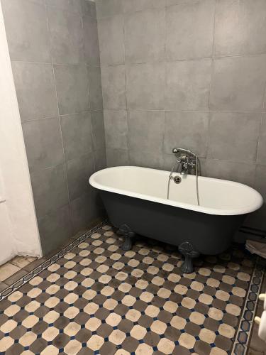 La salle de bains est pourvue d'une baignoire et de carrelage. dans l'établissement Grand Maison avec Piscine et Sauna, à La Ferté-Gaucher