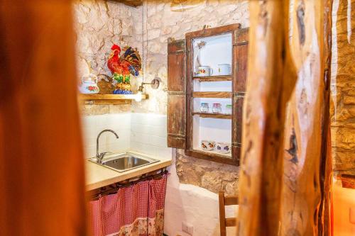 een kleine keuken met een spoelbak en een spiegel bij Le Fanciulle - Anita in Baunei