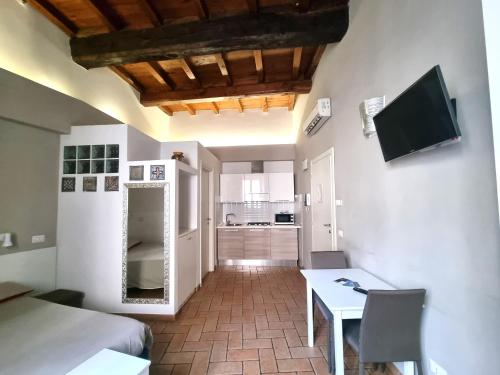 a living room with a table and a kitchen at H2 Via Saffi in Viterbo