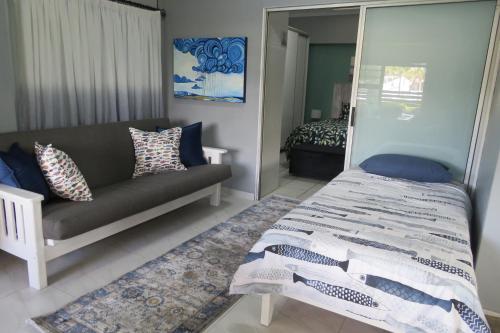 a living room with a couch and a bed at Destiny Jeffreys bay in Jeffreys Bay