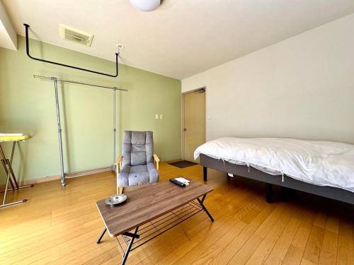a bedroom with a bed and a table and a chair at 美咲旅館 in Sakaide