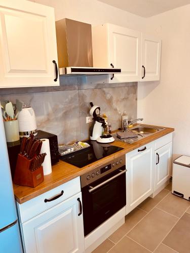 a kitchen with white cabinets and a black stove top oven at Swiss Apartments Rust in Rust