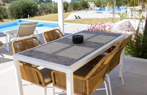 a white table with chairs and a cup on it at Nikiti Dream Villas in Nikiti