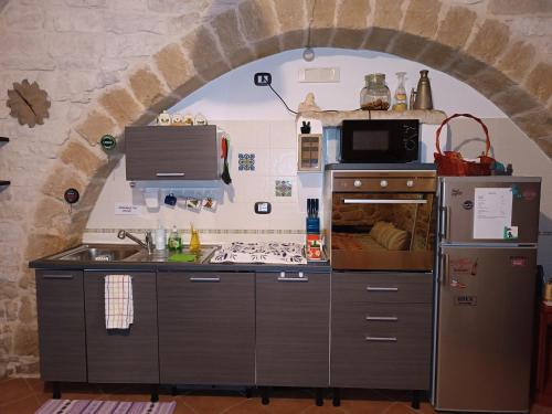a kitchen with an archway in a stone wall at Unique white stone Studio in Giovinazzo