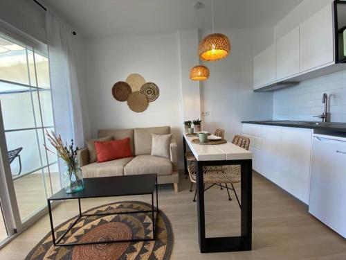 トロクス・コスタにあるApartamentos el Olivoのキッチンとテーブルとソファのあるリビングルーム