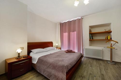 a bedroom with a bed and a pink curtain at Il Girasole Bed and Breakfast in Donnas