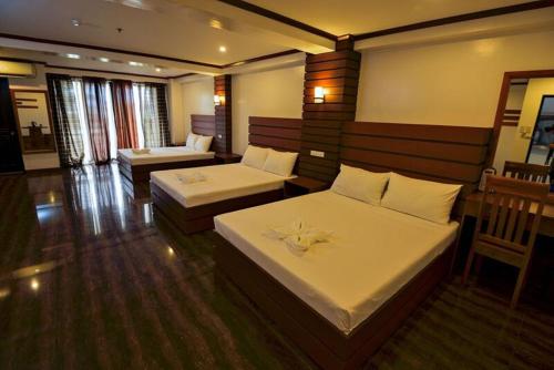 ein Hotelzimmer mit zwei Betten und einer Couch in der Unterkunft Abozza Resort in Boracay