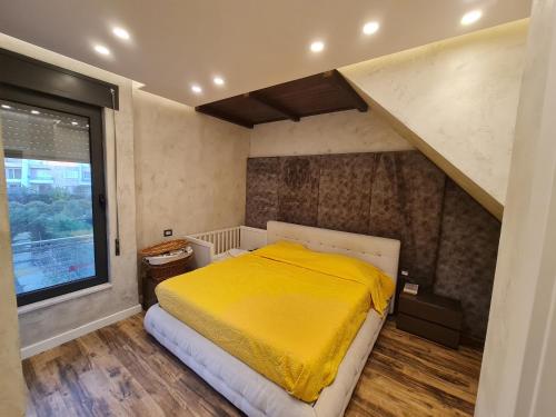 a bedroom with a yellow bed and a staircase at Lavender Beach House in Draç