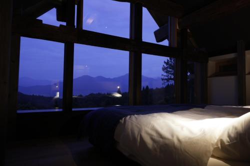 a bedroom with a bed and a large window at Satoyama Jujo The House in Minami Uonuma