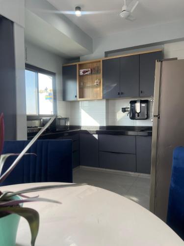 a kitchen with black cabinets and blue appliances at Casa de Rhythm in Jodhpur