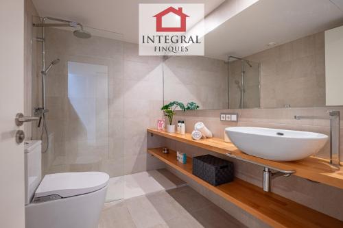 ein Badezimmer mit Waschbecken und Toilette in der Unterkunft El Coralí Apartament Palamós in Palamós