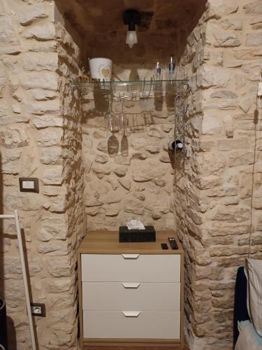 a bathroom with a stone wall with a vanity and a counter at Unique white stone Studio in Giovinazzo