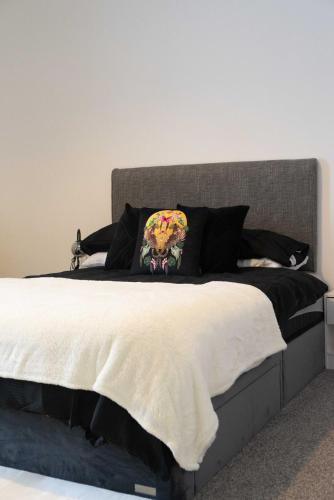 a bedroom with a large bed with a gray headboard at Thomson Haven in Carlisle