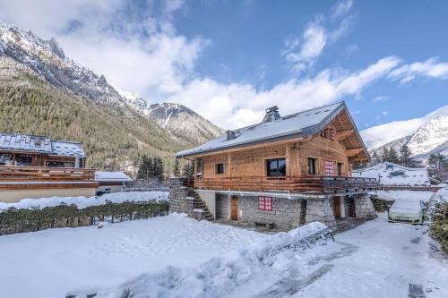 une maison en bois dans la neige avec des montagnes dans l'établissement Chalet Bossons - Welkeys, à Chamonix-Mont-Blanc