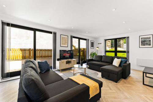 a living room with a couch and a tv at Contemporary Leeds Apartment - Free Parking in Leeds