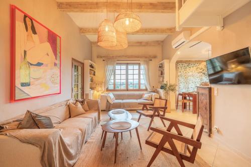 un salon avec un canapé et une table dans l'établissement Villa La Mauvaise Herbe - Welkeys, à Mougins