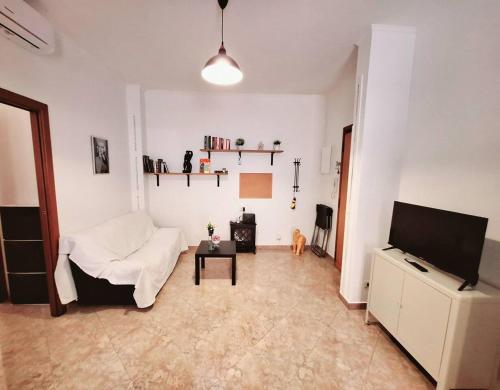 a living room with a white couch and a tv at CineMaison - Near Metro in Rome
