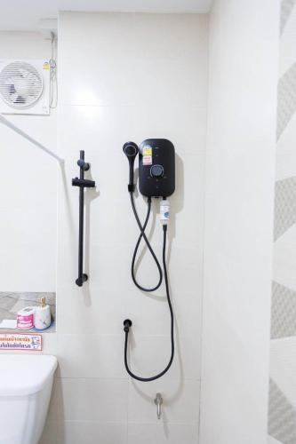 a shower in a bathroom with a blow dryer on the wall at โรงแรม เดอะกรีนนิช รีสอร์ท in Surin