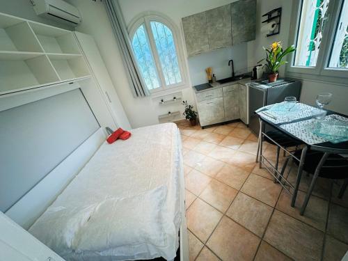 Un dormitorio con una cama y una mesa y una cocina. en Studio l'olivier, en Grasse