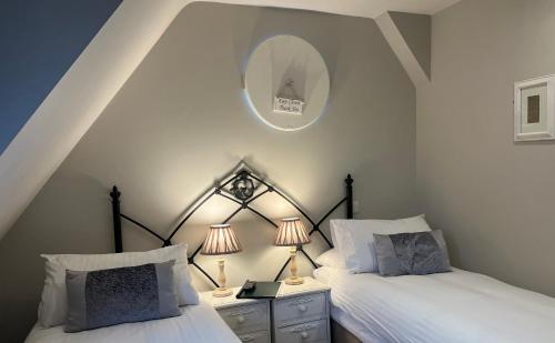 a bedroom with two beds and a mirror on the wall at Park Farm in Windsor