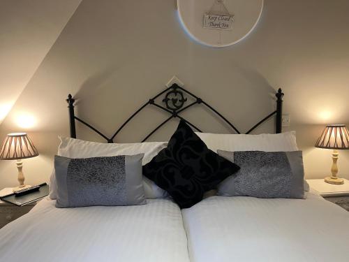 a bedroom with a white bed with black and white pillows at Park Farm in Windsor