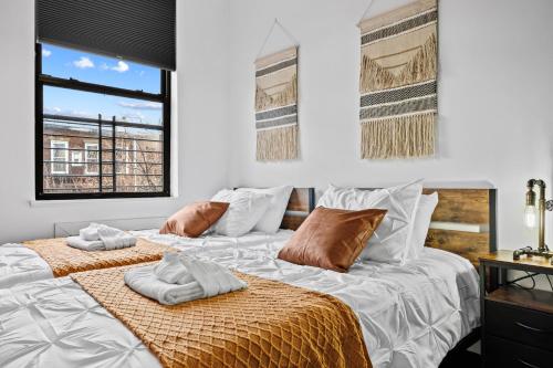two beds in a room with white walls at Rustic Chic 4BR for Groups - Bushwick's Finest Stay in Brooklyn