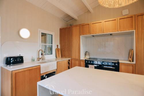 a kitchen with wooden cabinets and a white counter top at Villa du Golf in Les Portes