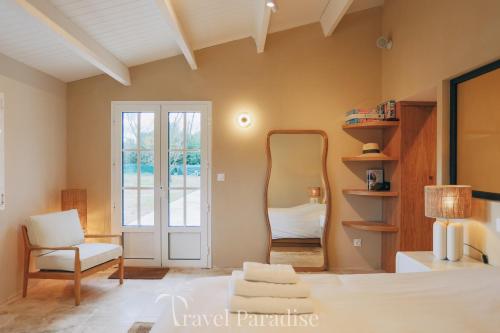 a bedroom with a mirror and a chair and a bed at Villa du Golf in Les Portes