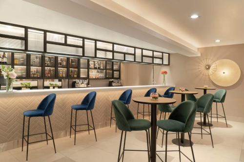 a restaurant with blue chairs and tables at NH Ciudad de Santiago in Santiago
